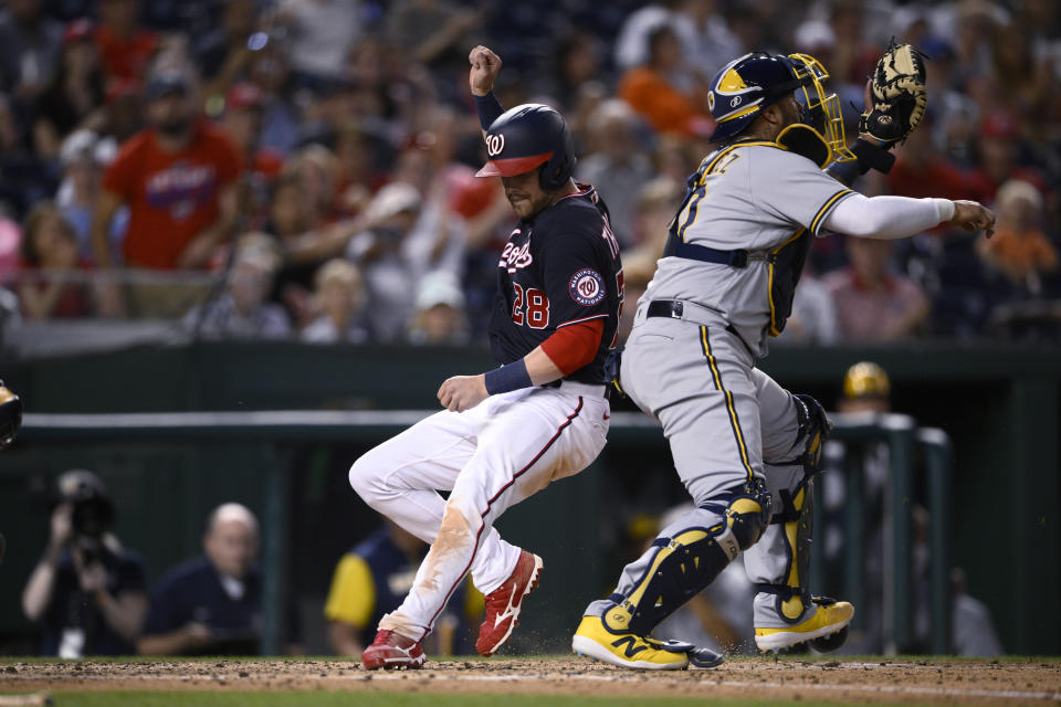 Washington Nationals' Lane Thomas scores past Milwaukee Brewers catcher Omar Narvaez on a single by Juan Soto during the fourth inning of a baseball game Friday, June 10, 2022, in Washington. (AP Photo/Nick Wass)