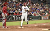 Texas Rangers' Joey Gallo scores the go-ahead run on an infield single by Rougned Odor off Los Angeles Angels relief pitcher Justin Anderson, while catcher Francisco Arcia watches during the eighth inning of a baseball game Thursday, Aug. 16, 2018, in Arlington, Texas. (AP Photo/Jeffrey McWhorter)