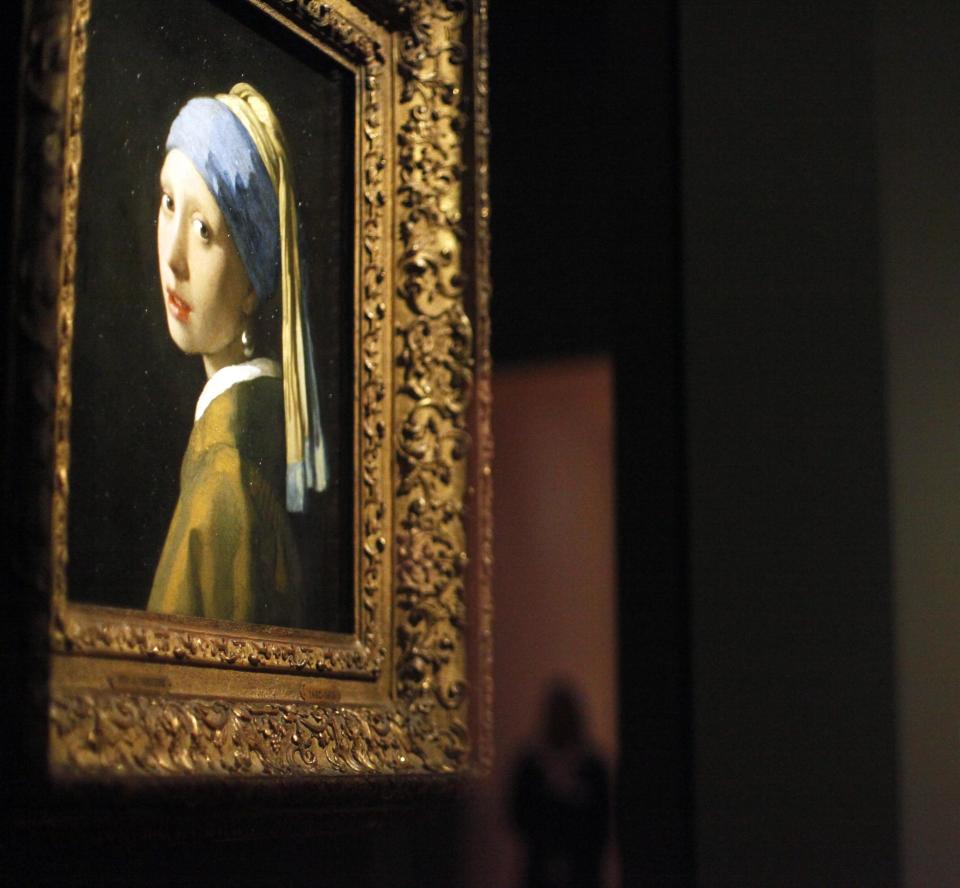 FILE - This June 19, 2013 file photo shows Johannes Vermeer’s famous painting "Girl With a Pearl Earring" part of the "Girl with a Pearl Earring: Dutch Paintings from the Mauritshuis" exhibit during a media preview at the High Museum of Art in Atlanta, one of a number of places the painting and other Dutch masterworks were exhibited while their home museum, the Mauritshuis in The Hague, underwent a two-year renovation. The museum in Holland reopens in June with the Vermeer and other paintings back in its collection. (AP Photo/Jaime Henry-White, File)