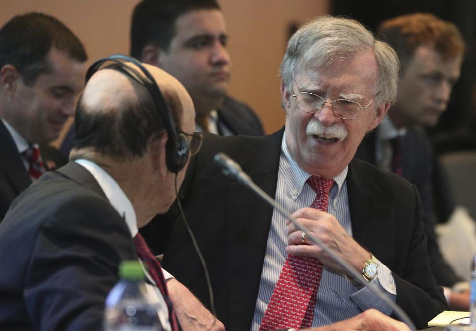 U.S. National security adviser John Bolton, right, speaks with U.S. Commerce Secretary Wilbur Ross during a conference of more than 50 nations that largely support Venezuelan opposition leader Juan Guaido in Lima, Peru, Tuesday, Aug. 6, 2019. Bolton says the U.S. will target anybody at home or abroad who supports the government of Venezuelan President Nicolas Maduro with stiff financial sanctions. Bolton spoke a day after the Trump administration announced a new round of sweeping measures aimed at pressuring Maduro from office. (AP Photo/Martin Mejia)