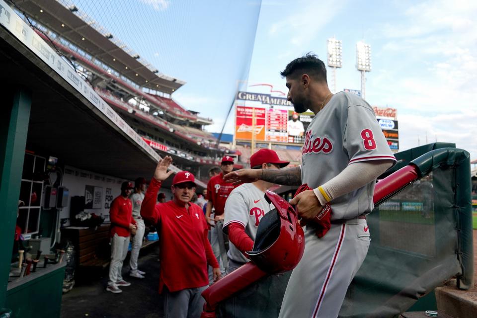 Philadelphia Phillies right fielder Nick Castellanos (8) is congratulated in the dugout after scoring a run in the third inning of a baseball game against the Cincinnati Reds, Monday, Aug. 15, 2022, at Great American Ball Park in Cincinnati. 
