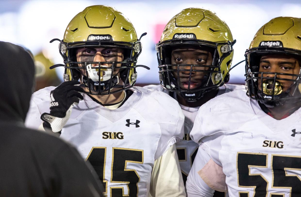 Sacred Heart-Griffin's Cory West (45), Ashton Bacon (53) and John Jones (55) listen to assistant coach Jim McMann on the sidelines as the Cyclones take on Joliet Catholic in the second half of the IHSA Class 4A Football State Championship at Huskie Stadium in Dekalb, Ill., Friday, November 26, 2021. [Justin L. Fowler/The State Journal-Register] 