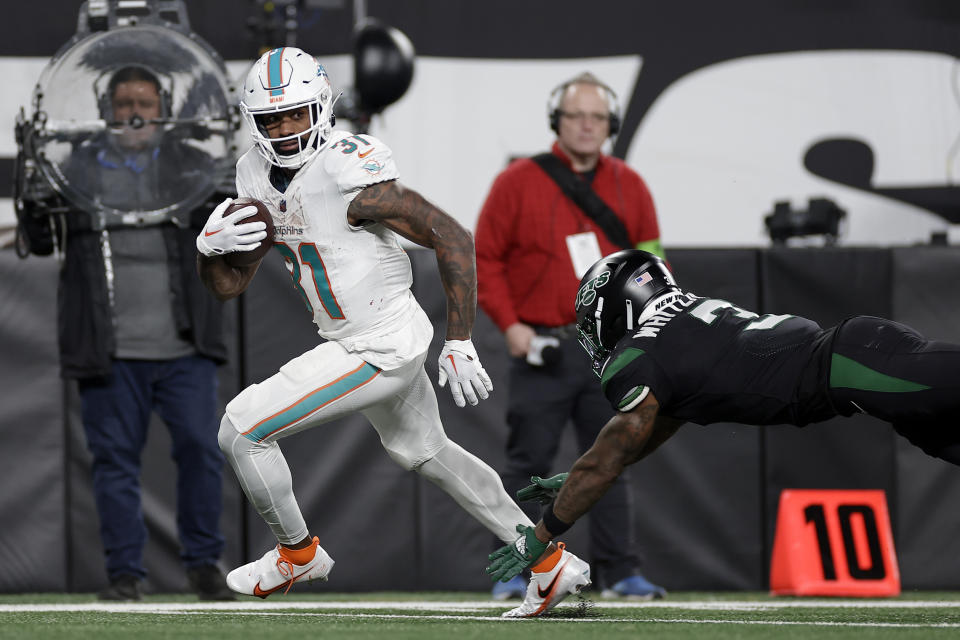 Miami Dolphins running back Raheem Mostert (31) gets past New York Jets safety Jordan Whitehead (3) and carries the ball into the end zone for a touchdown during the fourth quarter of an NFL football game, Friday, Nov. 24, 2023, in East Rutherford, N.J. (AP Photo/Adam Hunger)