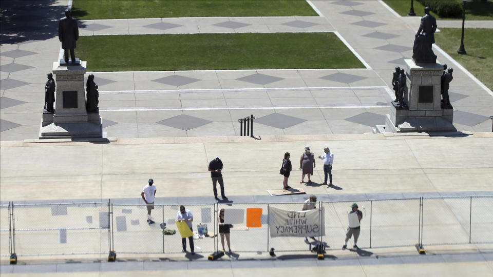 Demonstrators place signs on the fence protecting the Minnesota State Capitol Wednesday, June 17, 2020 in St. Paul, Minn. in the wake of the death of George Floyd in the custody of Minneapolis officers. The Legislature is meeting in special session with bills aimed at police accountability. Floyd died in police custody after video shared online by a bystander showed former officer Derek Chauvin kneeling on Floyds' neck during his arrest as he pleaded that he couldn't breathe. (AP Photo/Jim Mone)