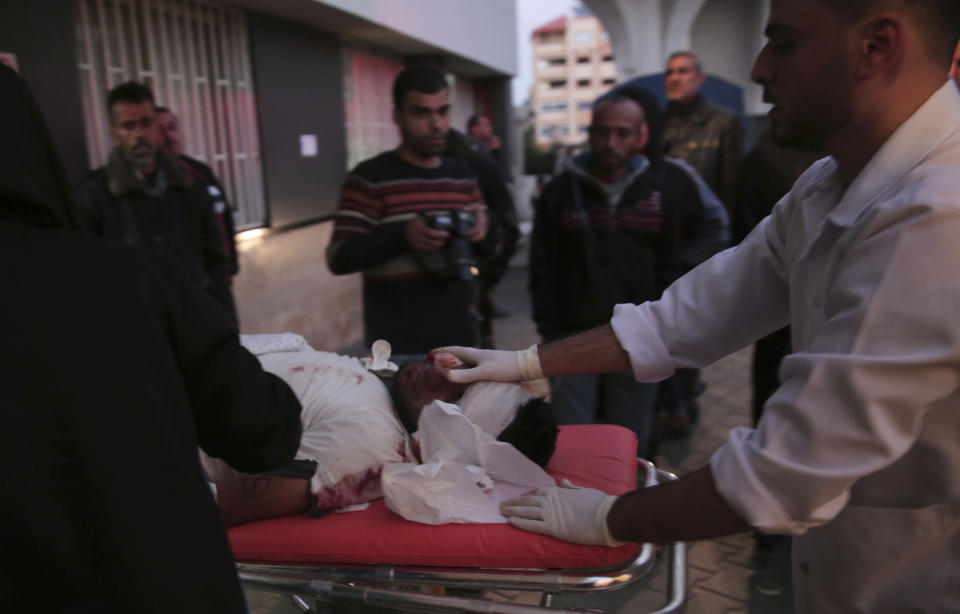 Palestinian medics move a wounded, who was shot by Israeli troops during a protest at the Gaza Strip's border with Israel, into the treatment room of Shifa hospital in Gaza City, Friday, Dec. 21, 2018. (AP Photo/Adel Hana)