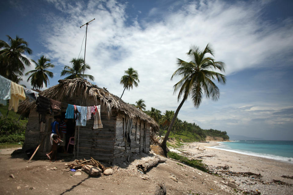 Two people walk into a thatched roof hut located along the shore in Barahona, Dominican Republic, Thursday, Aug. 23, 2012. Puerto Rico and the U.S. Virgin Islands braced for torrential rains on Thursday as Tropical Storm Isaac whipped up waves as high as 10 feet (3 meters) in the Caribbean and threatened to become a hurricane that could take a shot at Florida just as Republicans gather for their national convention. (AP Photo/Ricardo Arduengo)