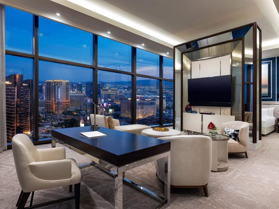 a bedroom with a living room separated by a wall with a TV with views of Las Vegas