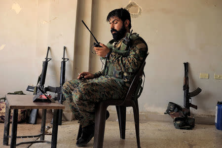 An officer of the Syrian Democratic Forces is pictured at their advance post as he talks through his walkie-talkie with his soldiers on the ground, in the old city of Raqqa. REUTERS/Zohra Bensemra