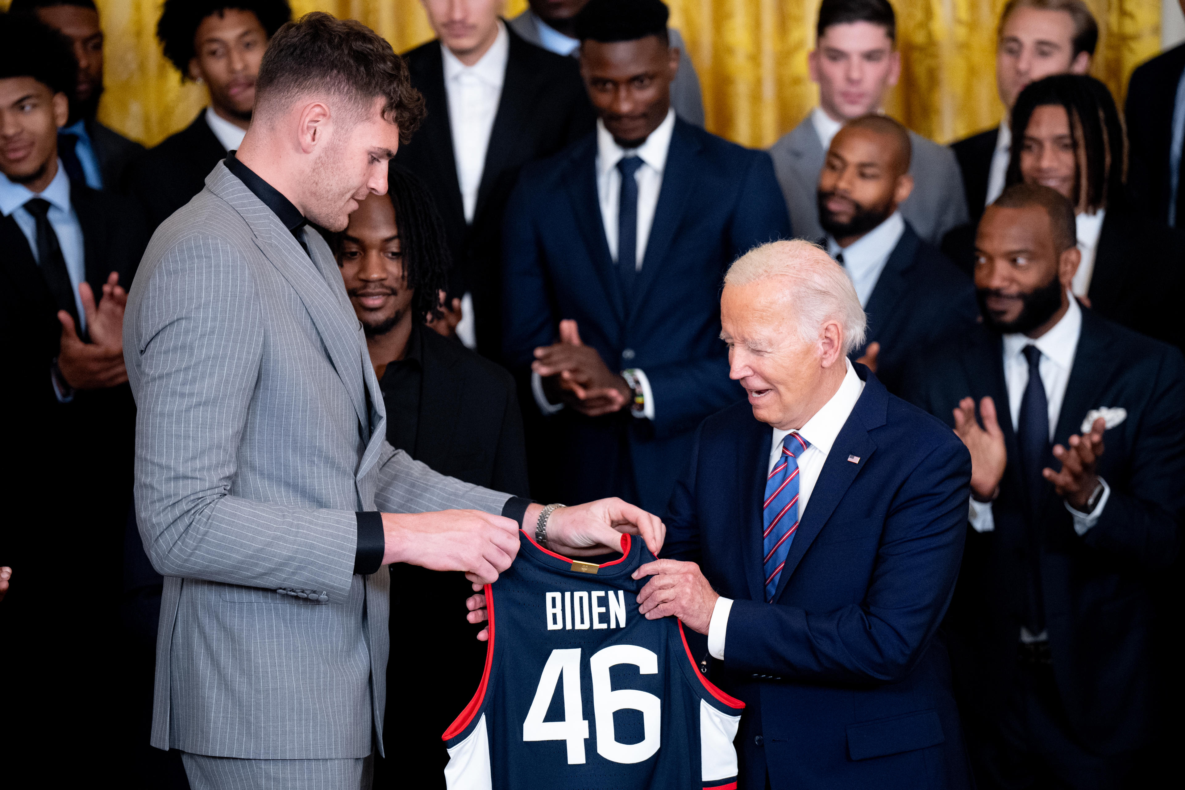 WASHINGTON, DC - SEPTEMBER 10: Center Donovan Clingan (L) presents U.S. President Joe Biden with a team jersey during a celebration of the 2023-2024 University of Connecticut Huskies Men's Basketball NCAA championship team in the East Room of the White House on September 10, 2024 in Washington, DC. The Huskies beat the Purdue Boilermakers 75-60 for their sixth NCAA Championship and their second championship in a row. (Photo by Andrew Harnik/Getty Images)