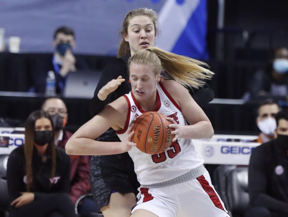 North Carlolina State's Elissa Cunane (33) drives around Virginia Tech's Elizabeth Kitley during the first half of an NCAA college basketball game in the Atlantic Coast Conference women's tournament in Greensboro, N.C., Friday, March 5, 2021. (Ethan Hyman/The News & Observer via AP)
