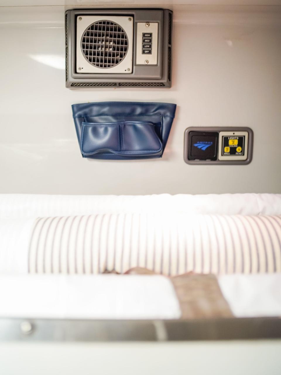 Air conditioning, a pocket for personal items, and light adjustment controls on the wall of the bedroom