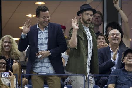 Television personality Jimmy Fallon (L) and actor and singer Justin Timberlake play around as they are shown on a video screen as they attend the quarterfinals match between Roger Federer of Switzerland and Richard Gasquet of France at the U.S. Open Championships tennis tournament in New York, September 9, 2015. REUTERS/Carlo Allegri