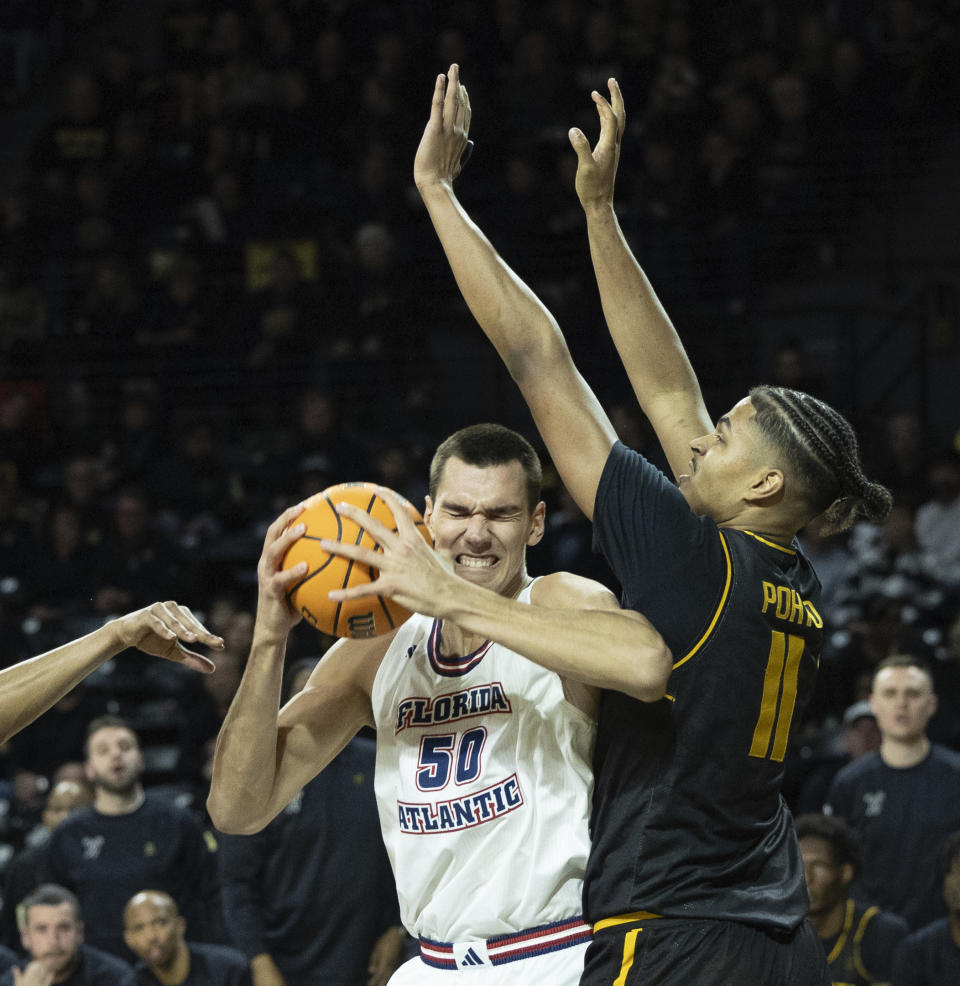 Florida Atlantic's Vladislav Goldin tries to get to the basket against Wichita State defender Kenny Pohto during the first half of an NCAA college basketball game on Sunday, Feb., 11, 2024, in Wichita, Kan. (Travis Heying/The Wichita Eagle via AP)