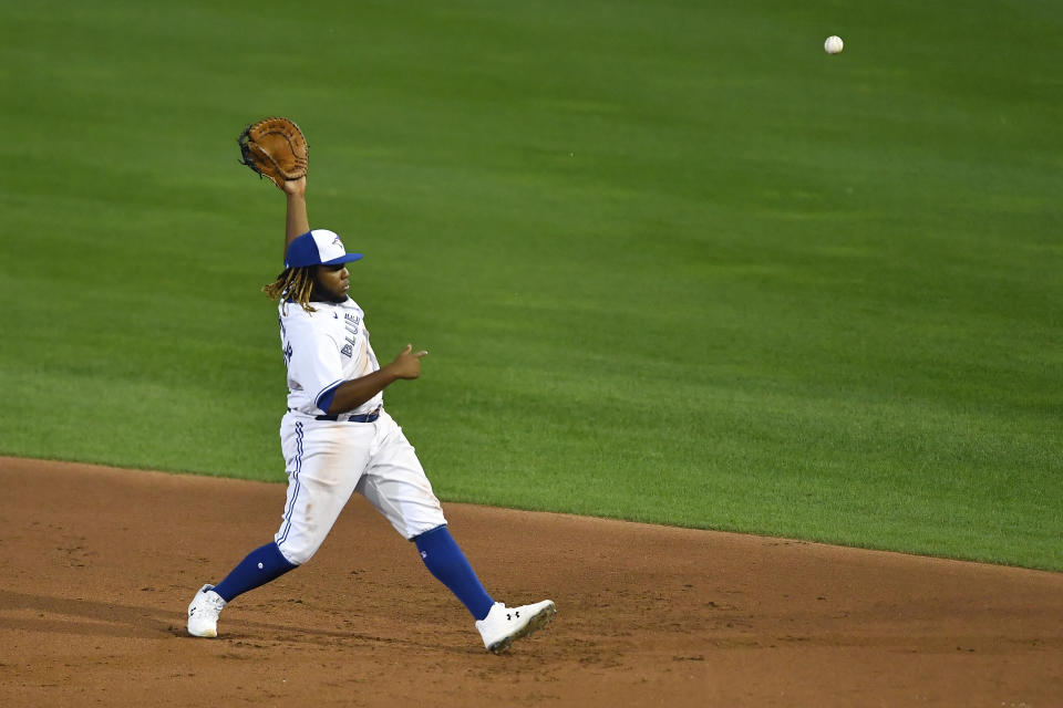 Toronto Blue Jays first baseman Vladimir Guerrero Jr. can't handle a ball hit by Boston Red Sox's Rafael Devers that would be a three-run triple during the sixth inning of a baseball game in Buffalo, N.Y., Tuesday, Aug. 25, 2020. (AP Photo/Adrian Kraus)