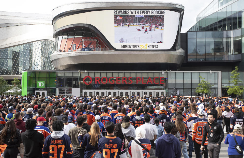 Edmonton Oilers fans watch coverage of Game 5 of the NHL hockey Stanley Cup Final between the Oilers and the Florida Panthers on a large screen Tuesday, June 18, 2024, in Edmonton, Alberta. (Jason Franson/The Canadian Press via AP)