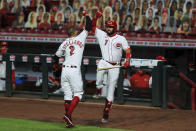 Cincinnati Reds' Nicholas Castellanos (2) celebrates his solo home run with teammate Eugenio Suarez (7) in the fourth inning during a baseball game against the Cleveland Indians in Cincinnati, Monday, Aug. 3, 2020. (AP Photo/Aaron Doster)