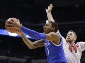 Kentucky's James Young (1) drives past Louisville's Stephan Van Treese (44) during the first half of an NCAA Midwest Regional semifinal college basketball tournament game Friday, March 28, 2014, in Indianapolis. (AP Photo/Michael Conroy)