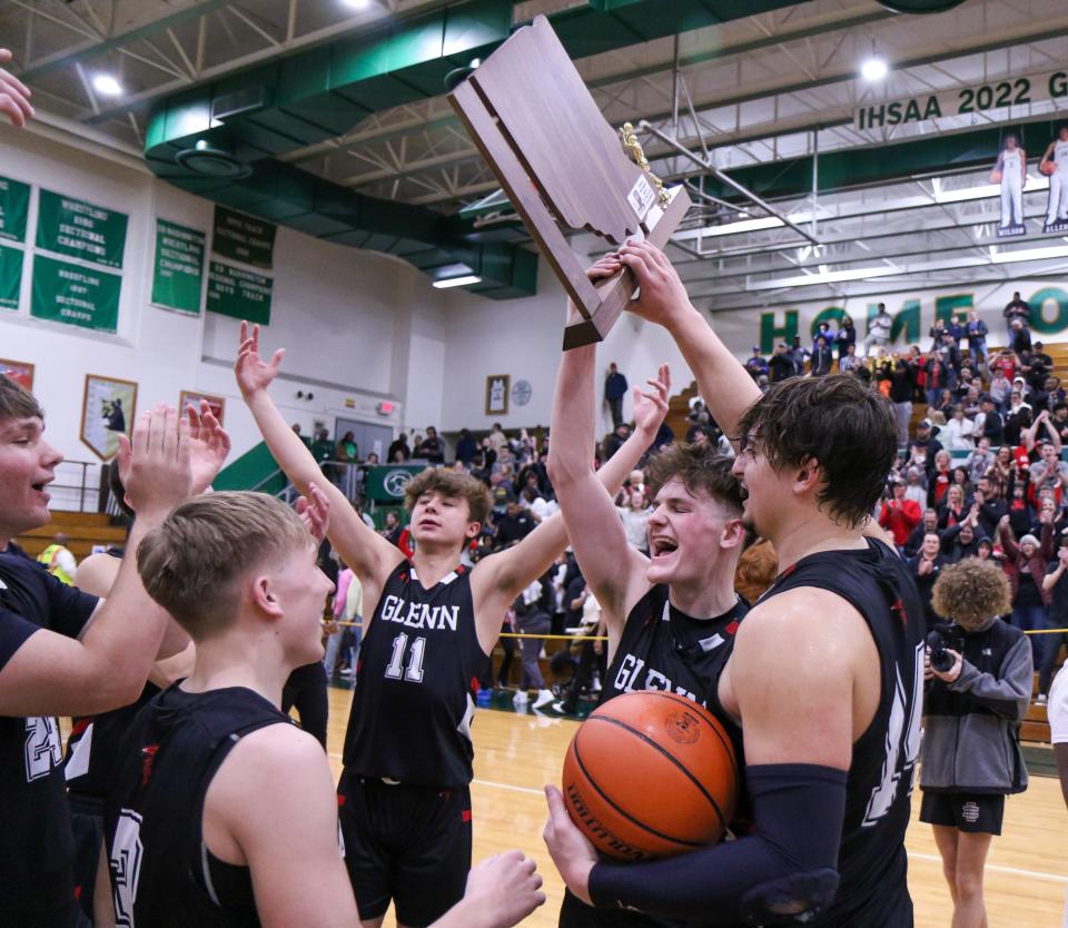 Member of Glenn's basketball team celebrate with the trophy following the IHSAA Regional Finals Saturday, Mar. 11, 2023 at Washington High School.