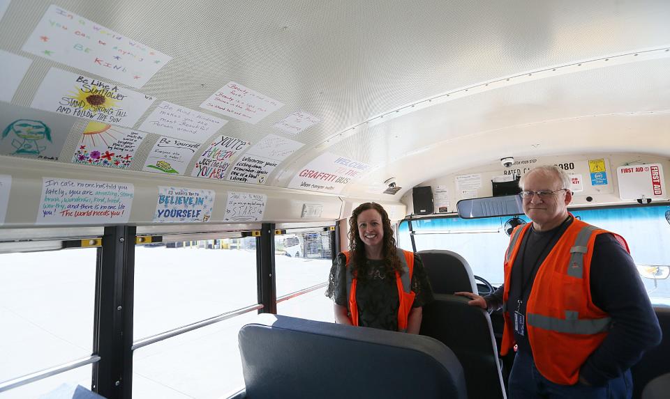 Sara Knight, general manager, and Russ Fulton, supervisor of safety and training at Durham School Services,  show the positive graffiti displayed inside a school bus that will transport students in the Ames school district.