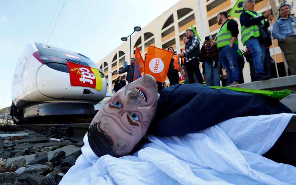 A puppet depicting French President Emmanuel Macron lies on the railway tracks by protesters in Nice to block a TGV high speed train - REUTERS/Eric Gaillard 