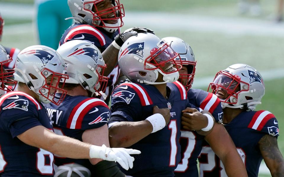 New England Patriots quarterback Cam Newton (1) celebrates his rushing touchdown against the Miami Dolphins with teammates in the first half of an NFL football game, Sunday, Sept. 13, 2020, in Foxborough, Mass. - AP