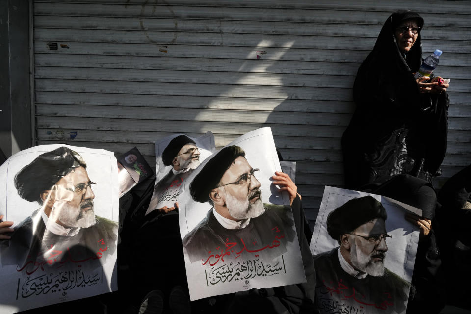 Mourners hold posters of the late Iranian President Ebrahim Raisi during a funeral ceremony for him and his companions who were killed in a helicopter crash on Sunday in a mountainous region of the country's northwest, in Tehran, Iran, Wednesday, May 22, 2024. Iran's supreme leader presided over the funeral Wednesday for the country's late president, foreign minister and others killed in the helicopter crash, as tens of thousands later followed a procession of their caskets through the capital, Tehran. (AP Photo/Vahid Salemi)