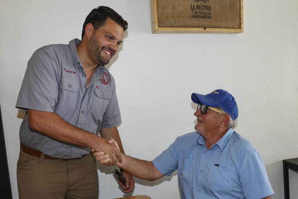 Georgia Republican state Rep. Steven Sainz shakes hands with Mike Perry, right, while campaigning at a coffee shop in Kingsland, Ga., Tuesday, June 11, 2024. Perry, a Sainz voter, says the expanded use of AI in politics is inevitable, but wondered how voters would be able to differentiate between what's true and what's not. “It’s free speech, you know, and I don’t want to discourage free speech, but it comes down to the integrity of the people putting it out," he said. "And I don’t know how you regulate integrity. It’s pretty tough.” (AP Photo/Gary McCullough)