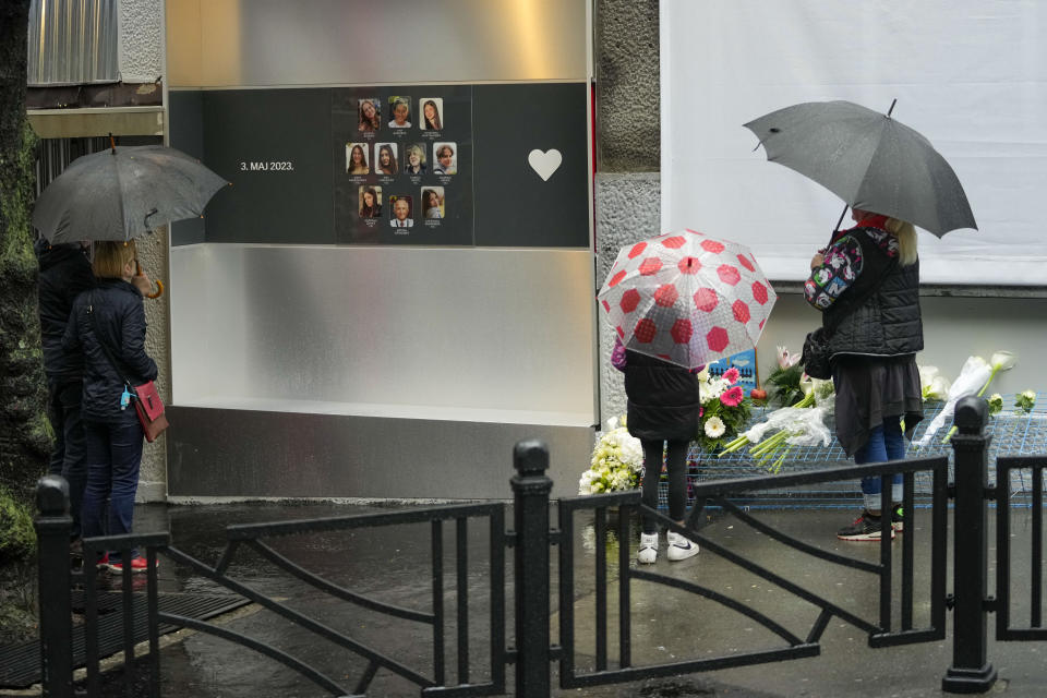 People stand in front of the Vladislav Ribnikar school prior to a ceremony to mark the first anniversary of a shooting that killed 10 people in Belgrade, Serbia, Friday, May 3, 2024. (AP Photo/Darko Vojinovic)