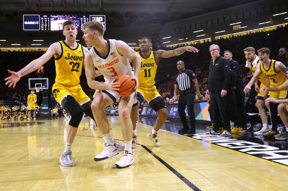 Iowa’s Patrick McCaffery (22) and Tony Perkins (11) defend Illinois’ Marcus Domask (3) Sunday, March 10, 2024 at Carver-Hawkeye Arena in Iowa City, Iowa.