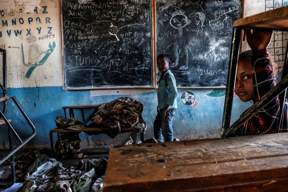 Children look on in a classroom with abandoned Tigrayan forces uniforms at an elementary school in the village of Bisober in Ethiopia's Tigray region. (Eduardo Soteras/AFP via Getty Images)