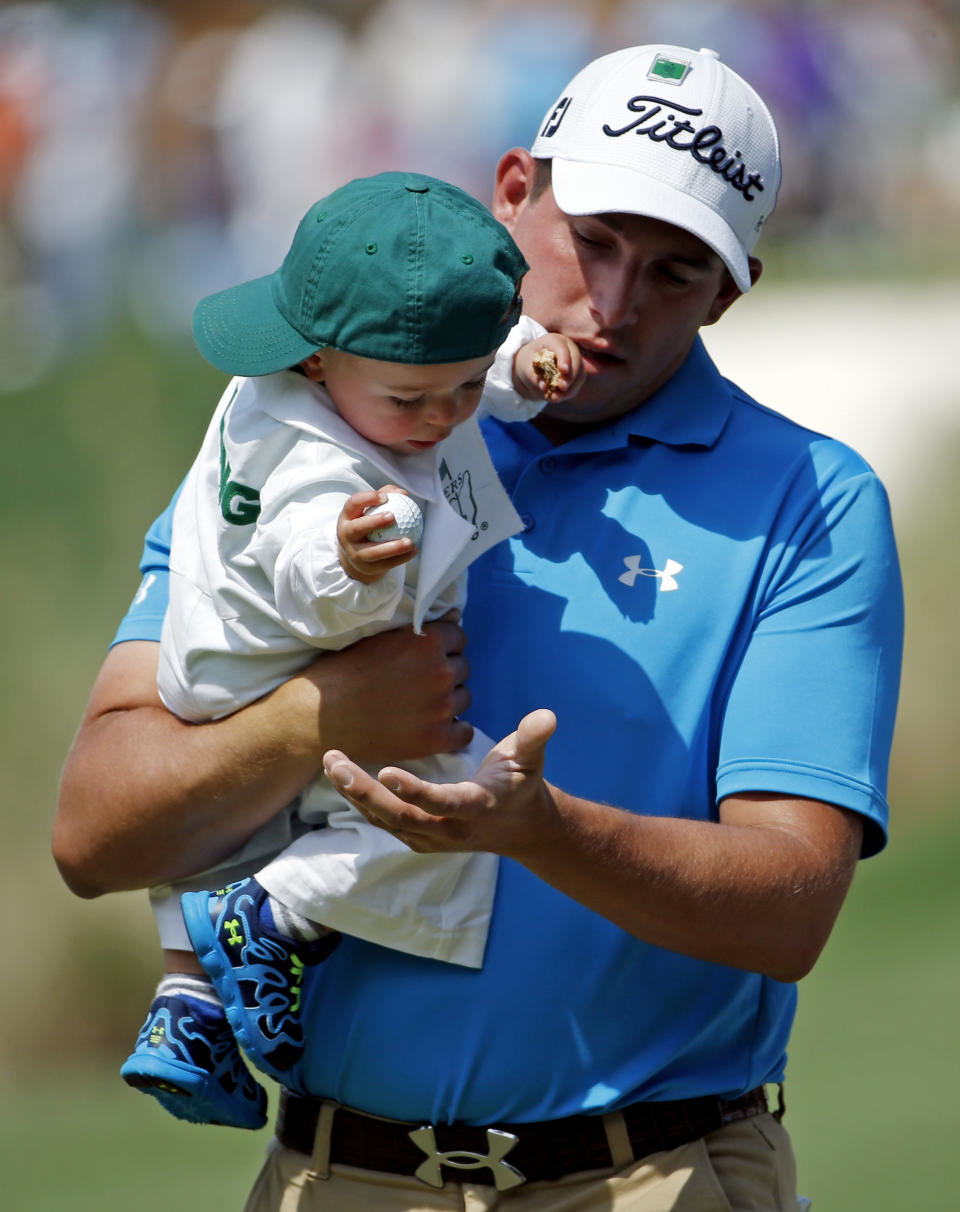Scott Stallings gets a golf ball from his son Finn during the par three competition at the Masters golf tournament Wednesday, April 9, 2014, in Augusta, Ga. (AP Photo/Matt Slocum)