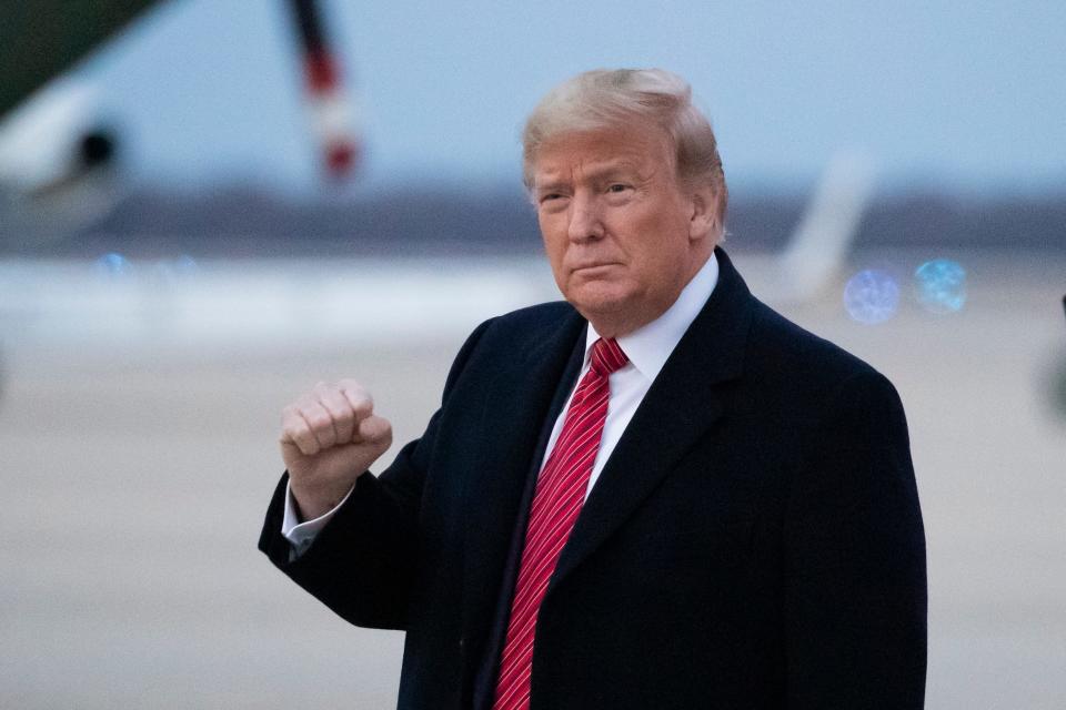 President Donald Trump pumps his fist as he steps off Air Force One as he arrives Sunday, Feb. 16, 2020, at Andrews Air Force Base, Md.