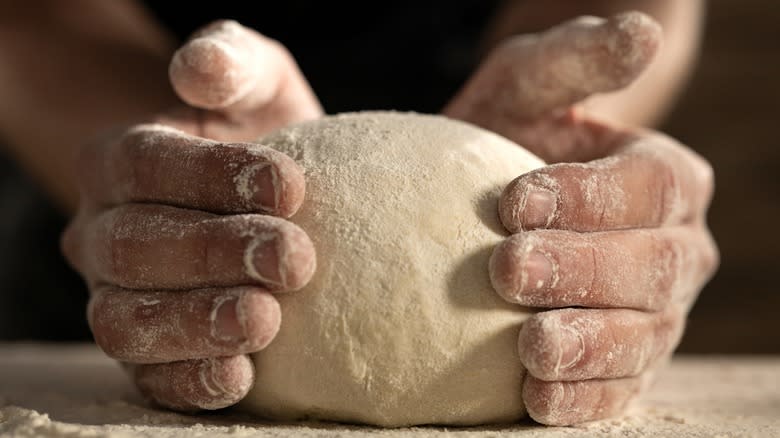 Hands holding bread dough