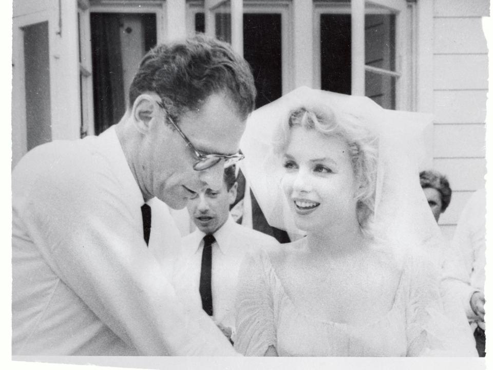 Marilyn Monroe wears a veil and looks at Arthur Miller on their wedding day.