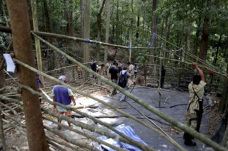 Security forces and rescue workers inspect at abandoned camp in a jungle in Thailand's southern Songkhla province May 5, 2015. REUTERS/Surapan Boonthanom