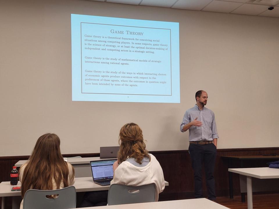 FHU's professor of mathematics Dr. Jared Collins, a avid game player and mathematician, leads a discussion about game theory in Dr. John McLaughlin's Games in Literature course. He reviewed the strategy behind such games as "Count Your Chickens," "Tic, Tac, Toe" and "Monopoly."