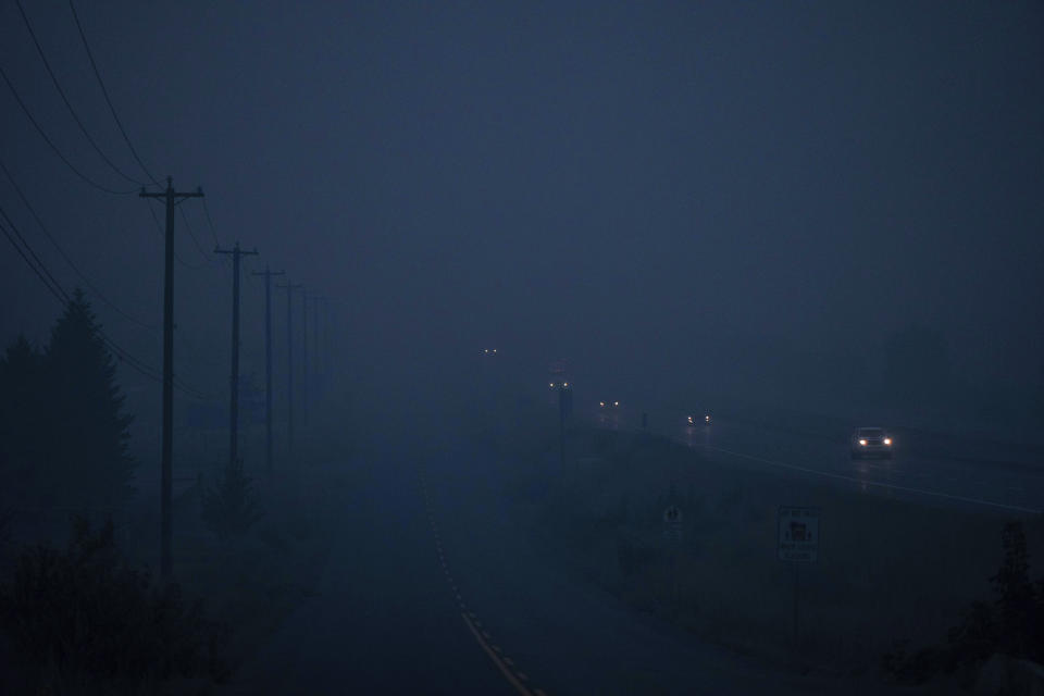 Thick smoke from wildfires burning in the area hangs in the air as motorists travel on the Trans-Canada Highway east of Kamloops, British Columbia, on Sunday, Aug. 20, 2023. (Darryl Dyck/The Canadian Press via AP)