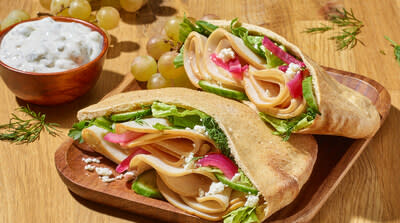 HORMEL® NATURAL CHOICE® Rotisserie Seasoned Deli Chicken Breast, as part of an appetizing chicken pita sandwich.