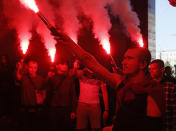 FILE - In this Sept. 5, 2019, file photo, volunteers with the right-wing paramilitary Azov National Corps light flares during a rally at the appeals court, as they protest against release Volodymyr Tsemakh, former commander of Russian-backed separatist forces in eastern Ukraine, in Kiev, Ukraine. Tensions are rising over the conflict in eastern Ukraine, with growing violations of a cease-fire and a massive Russian military buildup near its border with the region. (AP Photo/Efrem Lukatsky, File)