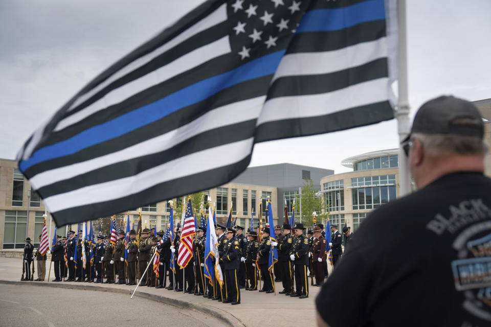 Retired New Richmond police officer Thomas Wolf holds a flag outside the funeral service for St. Croix County Sheriff’s Deputy Kaitlin “Kaitie” R. Leising, Friday, May 12, 2023 in Hudson, Wis.. Hundreds of law enforcement officers from several states joined other mourners in paying final respects Friday to a Wisconsin sheriff’s deputy who was fatally shot by a suspected drunken driver during a traffic stop. (Glen Stubbe/Star Tribune via AP)