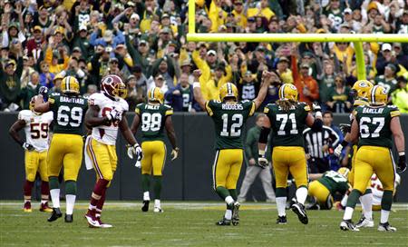 Green Bay Packers quarterback Aaron Rodgers (C) celebrates a touch down against the Washington Redskins during the first half of their NFL football game in Green Bay, Wisconsin September 15, 2013. REUTERS/Darren Hauck