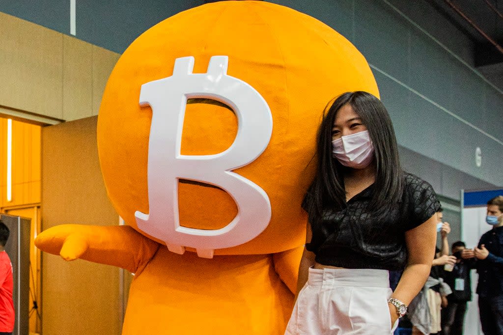 A woman poses with a Bitcoin mascot during the Thailand Crypto Expo 2022 on May 14, 2022 (Getty Images)