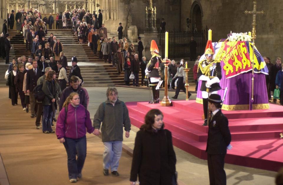Las personas caminan frente al ataúd de la Reina Madre en el Westminster Hall en 2002 (Stefan Rousseau/PA) (PA Archive)