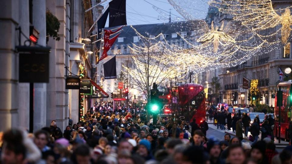 File image showing crowds of shoppers at dusk walking along Regent Street under Christmas lights