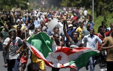 Protesters carry a Burundi flag during a protest against President Pierre Nkurunziza's decision to run for a third term in 2015 - Credit: REUTERS/Goran Tomasevic