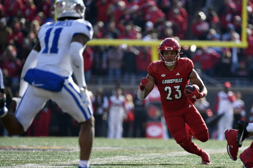 Louisville running back Isaac Guerendo (23) runs through an opening in the Kentucky defense during the second half of an NCAA college football game in Louisville, Ky., Saturday, Nov. 25, 2023. Kentucky won 38-31. (AP Photo/Timothy D. Easley)