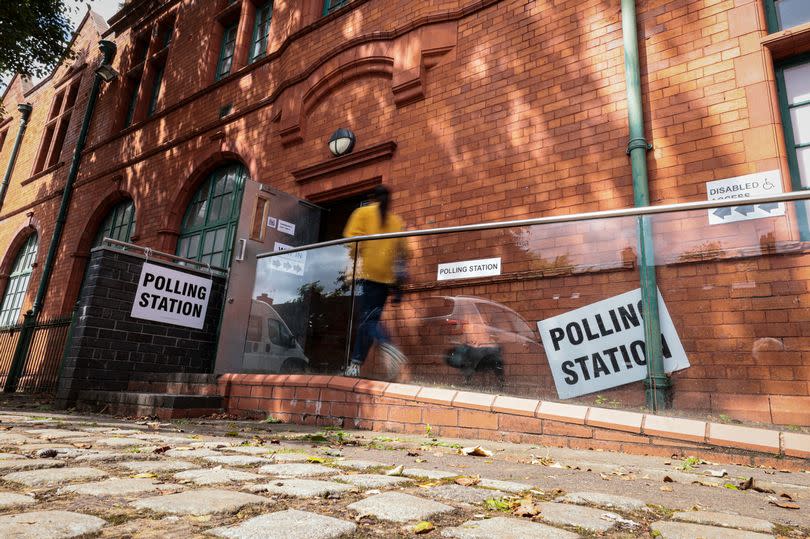 A woman enters Salford Lads Club to cast her vote