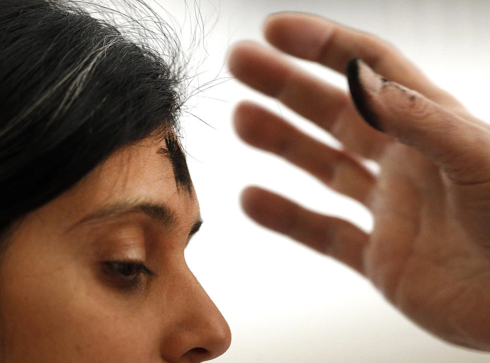 Ashes received from a priest mark the forehead of a parishioner during an Ash Wednesday Mass in Baltimore, Wednesday, March 5, 2014. Ash Wednesday marks the beginning of the Lenten season, a time when Christians commit to acts of penitence and prayer in preparation for Easter Sunday. (AP Photo/Patrick Semansky)