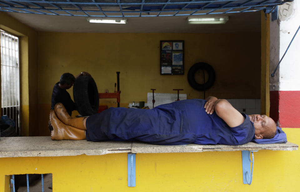 A mechanic sleeps at a service station on the outskirts of Havana May 28, 2013. REUTERS/Desmond Boylan (CUBA - Tags: SOCIETY BUSINESS EMPLOYMENT)