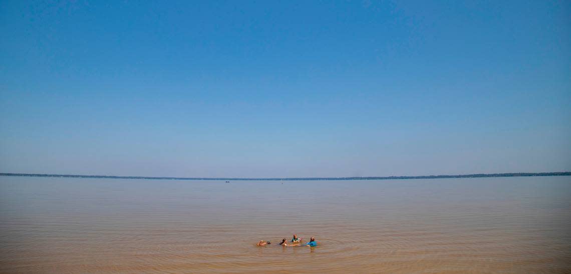 Children from the Brunswick County Wild + Free homeschool group play in the shallow water at Lake Waccamaw State Park.